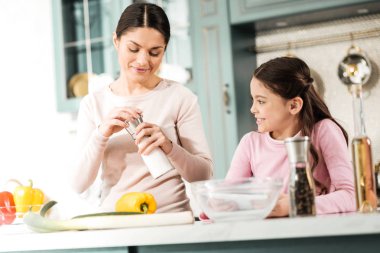 Onun mutfak ekipmanları gösteren pozitif memnun kadın