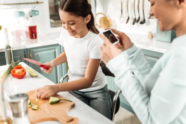 Sevimli uzun saçlı çocuk annesi sofraya yardım