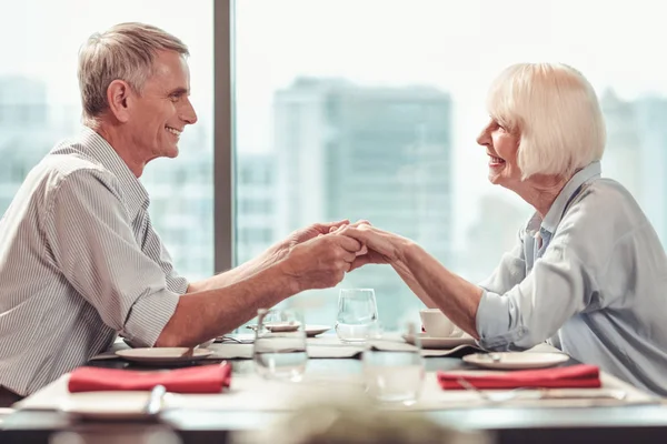 Aufgeregtes Rentnerpaar freut sich gemeinsam im Café — Stockfoto