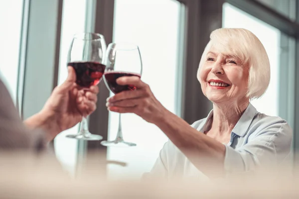 Schöne Rentnerin trinkt Wein mit einem Mann — Stockfoto