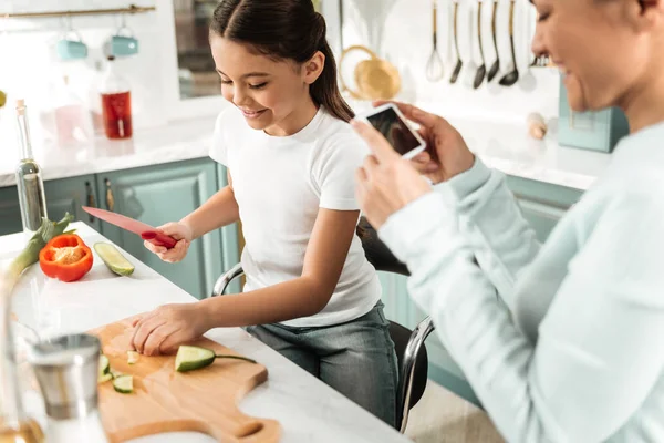 Sevimli uzun saçlı çocuk annesi sofraya yardım