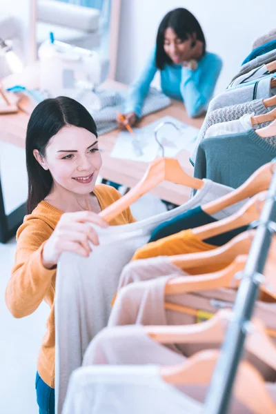 Leuk meisje kiezen nieuwe trui op showroom — Stockfoto