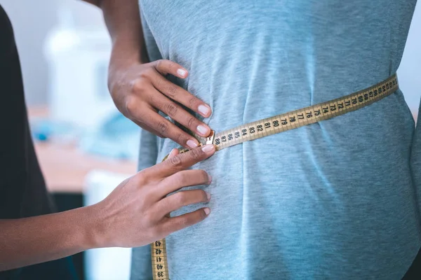 Vue des couturières mains mesurant la taille des clients — Photo