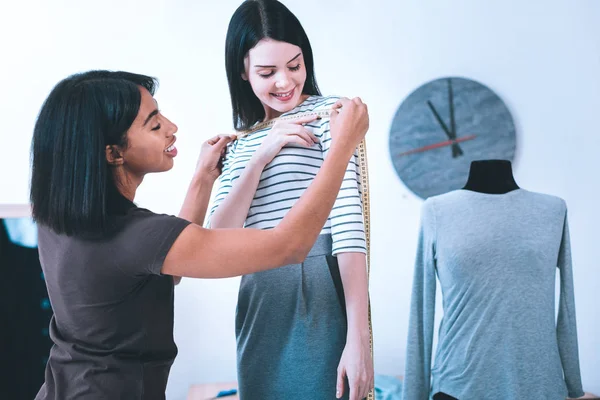 Las costureras jóvenes que toman medidas entre sí — Foto de Stock