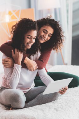 Kız giyiyor koyu kırmızı gömlek onun akrabası sarılma gülümseyen