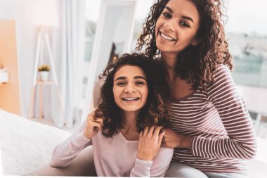 Koltuk dekoratif bitkiler yakın oturan iki gülümseyen kız