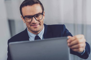 Dizüstü bilgisayar ekranına bakarak akıllı kendine güvenen adam