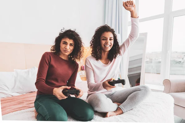 Curly encantador menina sentindo-se feliz após a vitória no jogo de vídeo — Fotografia de Stock