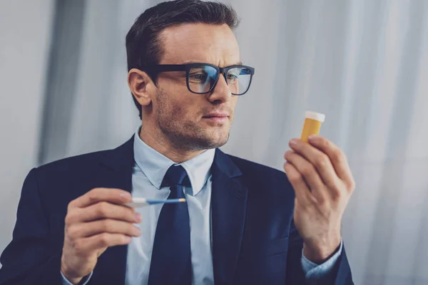 Nice homem sério segurando pílulas — Fotografia de Stock