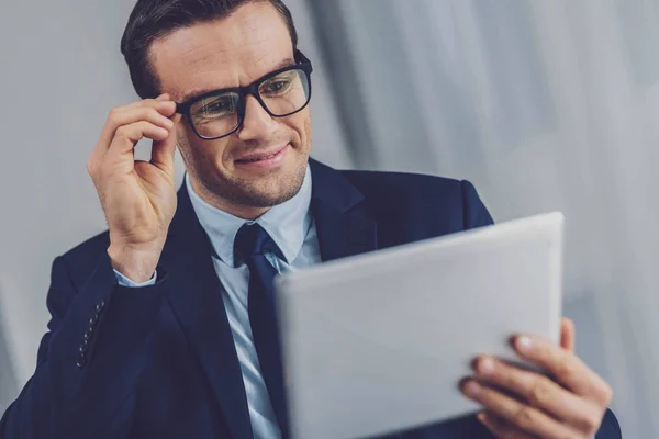 Alegre homem positivo olhando para a tela do tablet — Fotografia de Stock