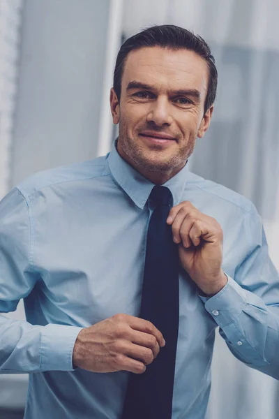 Joyful homem positivo segurando sua gravata — Fotografia de Stock