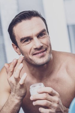 Neşeli esmer adam doğruca kameraya bakan