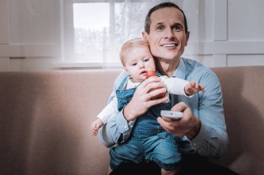 Bir uzaktan kumanda tutan güzel mutlu adam