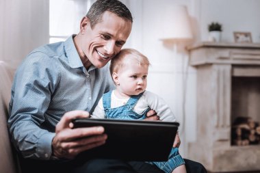 Tablet ekranına bakarak çok mutlu neşeli adam