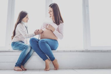 Güzel kız onun gelecekteki kardeş kalp atışı için dinleme