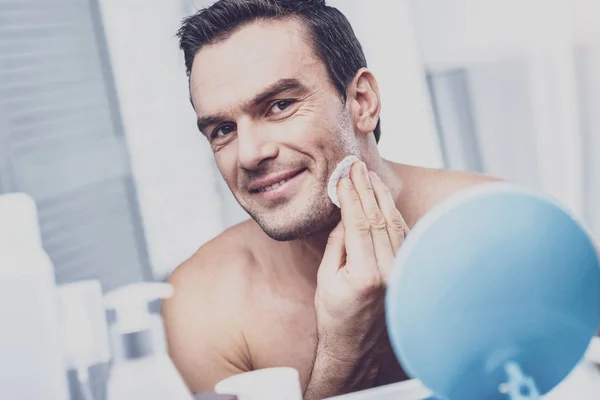 Radostné mladý muž dělá kosmetické procedury — Stock fotografie