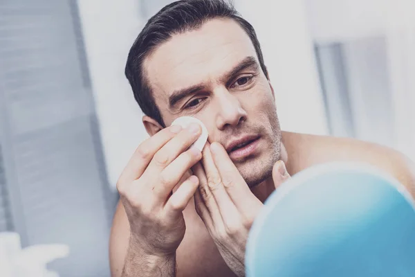 Deleitado modelo masculino limpiando su cara — Foto de Stock