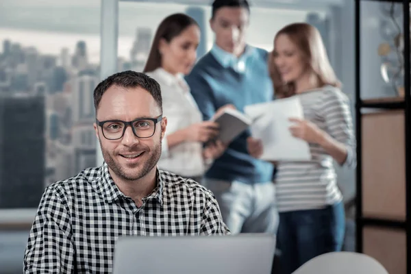 Blij man aan het werk op zijn laptop op het werk — Stockfoto