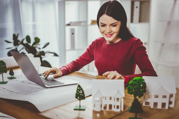 Glückliche positive Frau zeigt auf die Häuser — Stockfoto