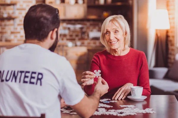 Charmig kvinna som håller ett pussel — Stockfoto