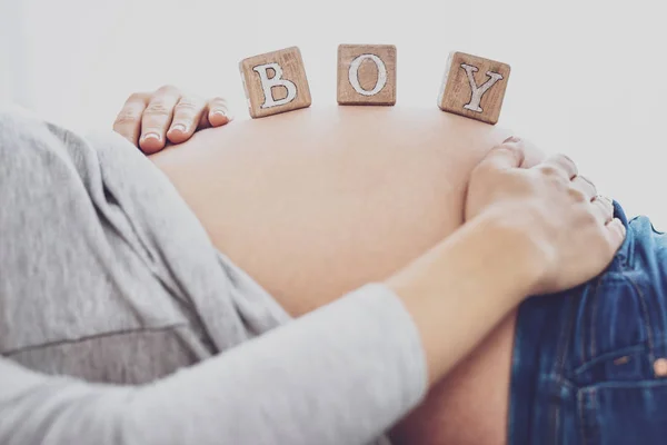 抱着砖头的孕妇的特写: 男孩 — 图库照片