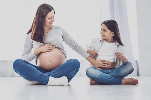 Fröhliche Schwangere berührt Bauch ihrer Tochter — Stockfoto