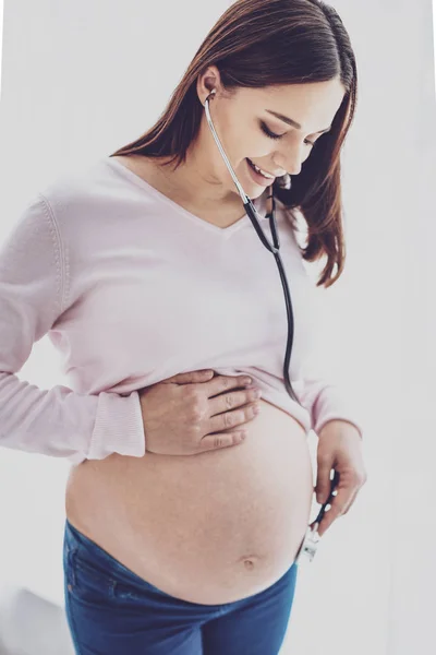 Mulher muito grávida ouvindo babys batimento cardíaco — Fotografia de Stock