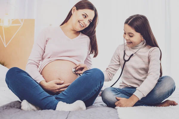 Izgatott lány hallgatja szívverés baba hasa anyák — Stock Fotó