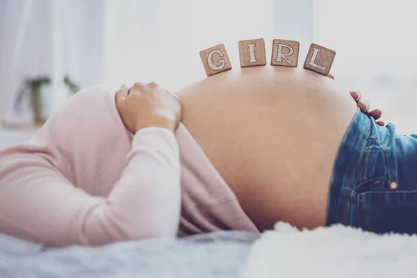 गर्भवती महिला ईंटें पकड़ रही है पेट पर लड़की कह रही है — स्टॉक फ़ोटो, इमेज