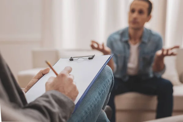 Ervaren psycholoog notities maken tijdens een sessie — Stockfoto