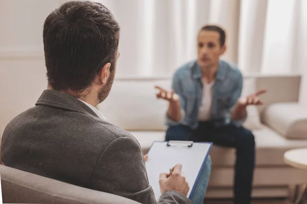 Psychologue veste grise à l'écoute de son client anxieux — Photo