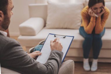 Koltukta oturan sakallı esmer psikolog