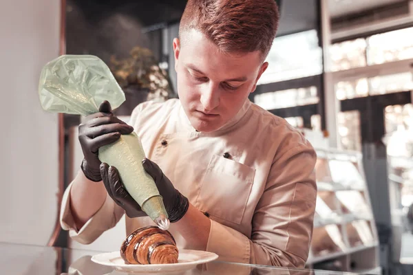 Chef do restaurante que decora o croissant com nata — Fotografia de Stock