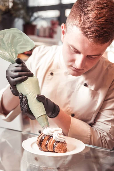 Cozinhe adicionando creme a uma deliciosa sobremesa — Fotografia de Stock