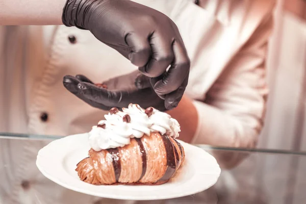 Pastelero añadiendo detalles decorativos al croissant dulce —  Fotos de Stock