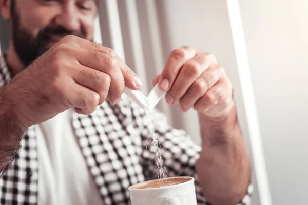 Man putting sugar in the cup of coffee — Stock Photo, Image