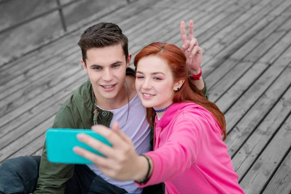 Nettes junges Paar lächelt, während es Selfies macht — Stockfoto