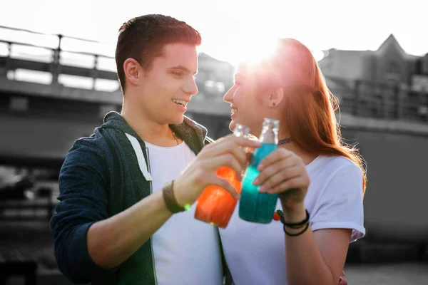 Young people hugging and drinking colorful lemonade — Stock Photo, Image