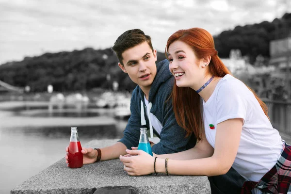 Dos jóvenes de pie en el muelle y relajándose con cócteles — Foto de Stock