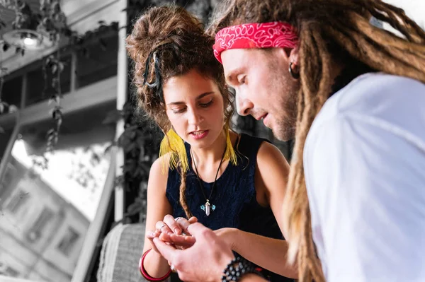 Γενειοφόρος φίλο με dreadlocks παρουσιάζοντας τη φίλη νέα εξαρτήματα — Φωτογραφία Αρχείου