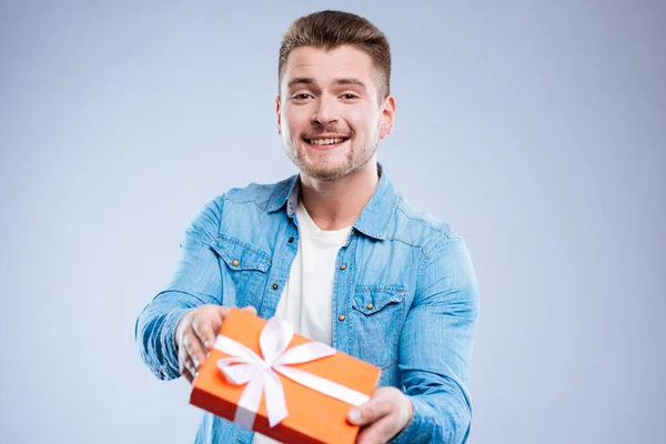 Alegre homem positivo segurando uma caixa de presente — Fotografia de Stock