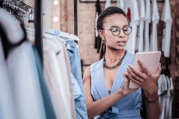 Mujer ocupada vistiendo traje elegante sosteniendo tableta lectura de correo electrónico de pie en la tienda — Foto de Stock