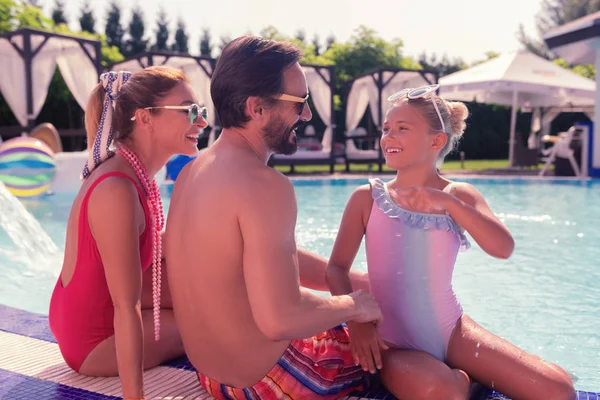 Leuk gelukkig meisje met haar ouders spreken — Stockfoto