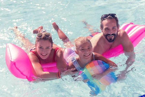 Joyful united family swimming together on the air bed