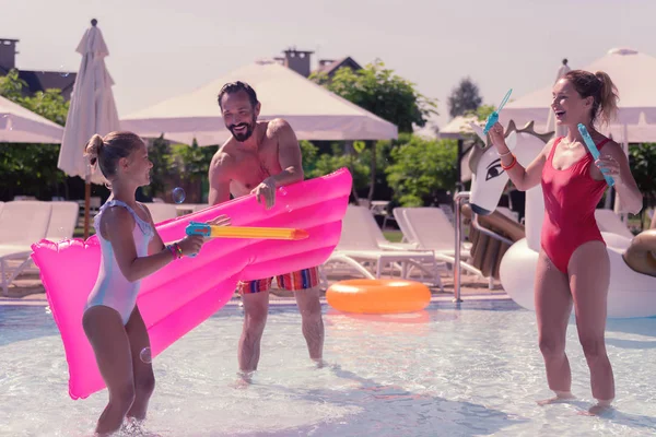 Joyful positive girl using a water gun