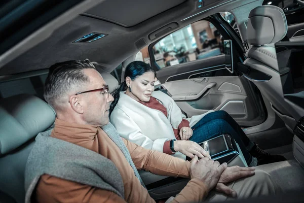 Aviomies yllään oranssi kilpikonna kaula valitsemalla auton vaimolleen — kuvapankkivalokuva