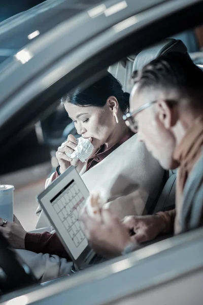 Overloaded businessmen working and eating in their car — Stock Photo, Image