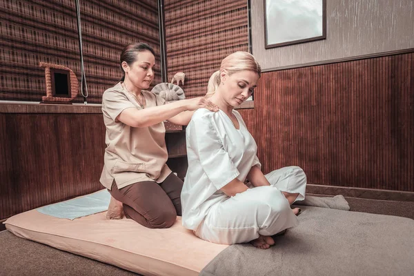 Professionelle weibliche Masseurin massiert ihre Kunden Schultern — Stockfoto