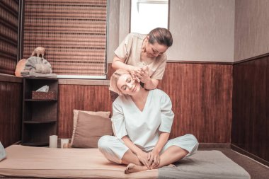 Minderin üzerine oturan memnun genç kadın