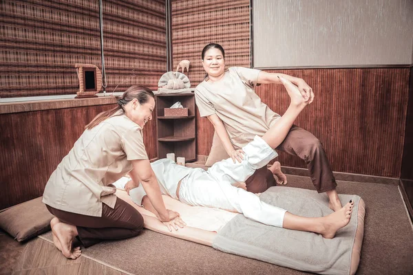 Pozytywne Asian kobieta podniesienie jej noga klientów — Zdjęcie stockowe